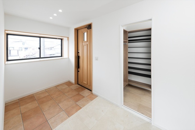 明るく広々とした玄関ホールは、大容量のシューズイン＆アウタークローク完備。生活感を隠して常に美しさを保てます。空間を引き締める木製扉のライン照明が高級感を演出し、日々の帰宅を優雅に迎える設計です。