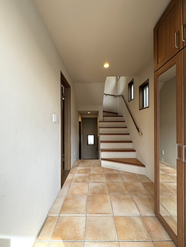 質感豊かなテラコッタ風タイルを敷き詰めた、開放感のある玄関ホール。姿見付きの収納が空間をより広く見せ、お出かけ前の身だしなみチェックにも便利です。デザイン性と実用性を兼ね備えた、こだわりのエントランス