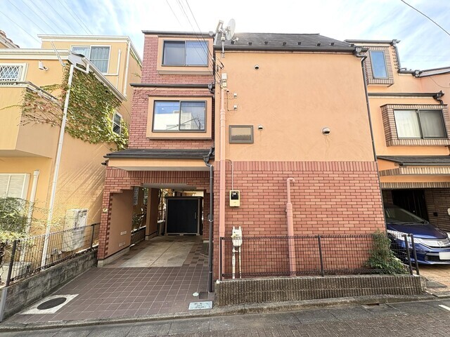 温かみのあるオレンジと上質なレンガ調タイルのコントラストが目を惹く外観。1階は、雨の日でも快適に乗り降りできる便利なビルトインガレージになっています。スタイリッシュな暮らしが叶う一棟です。