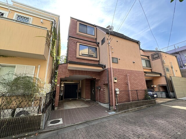 温かみのある外観デザインが街並みに映える一邸。アプローチ部分はタイル敷きで清潔感があり、屋根付きの駐車スペースは雨の日の乗り降りにも便利です。暮らしの快適さを高める工夫が詰まっています。